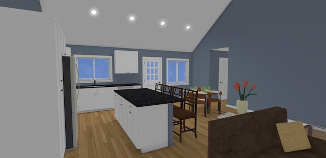199 Bert Berry Rd, Embden, ME 04958 - kitchen with freestanding refrigerator, a breakfast bar, a center island, dark countertops, and light wood finished floors