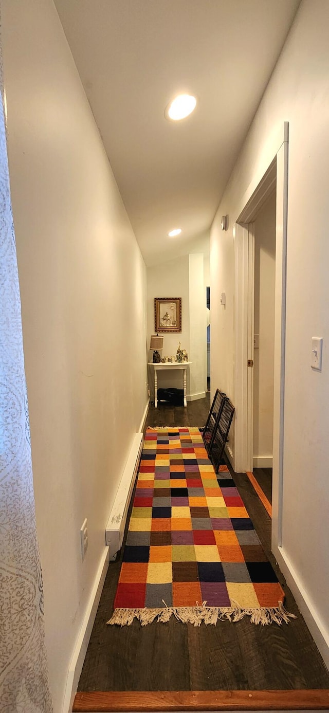 hallway featuring lofted ceiling and a baseboard heating unit