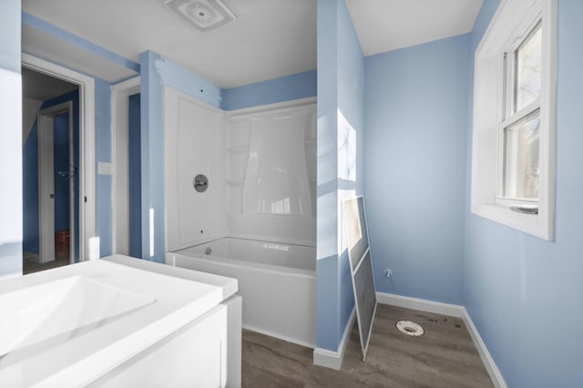 full bathroom featuring  shower combination, baseboards, and wood finished floors