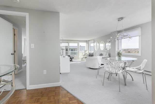 dining space with a textured ceiling, baseboard heating, and dark parquet floors