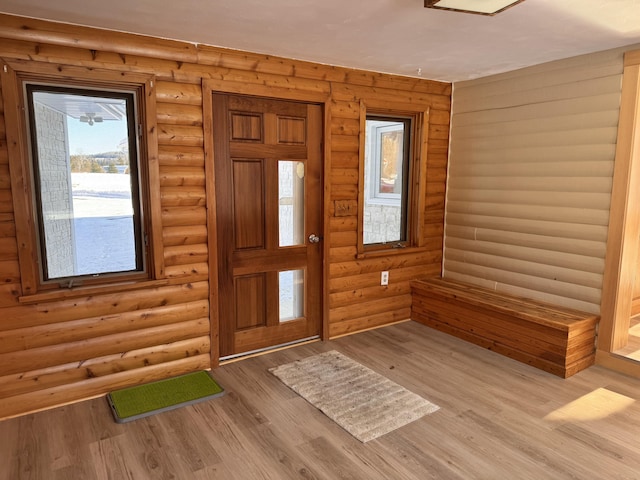 entryway featuring log walls and light hardwood / wood-style flooring