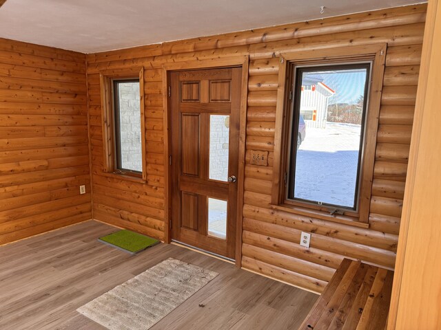 entrance foyer featuring hardwood / wood-style flooring and rustic walls