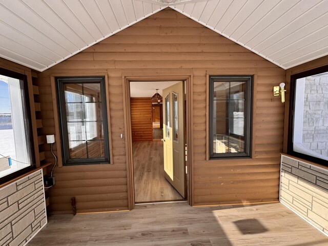 doorway featuring wood ceiling, lofted ceiling, and light wood-type flooring