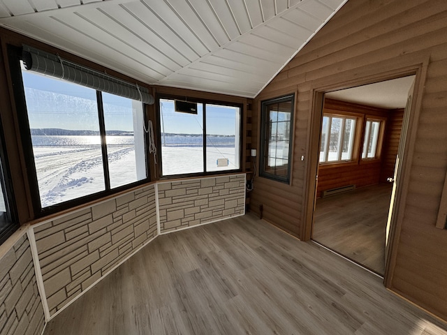 unfurnished sunroom featuring a water view, baseboard heating, a healthy amount of sunlight, and wood ceiling