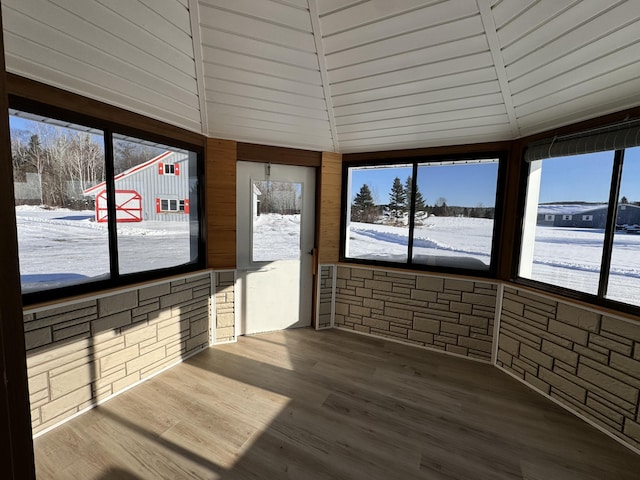 sunroom / solarium featuring lofted ceiling with beams