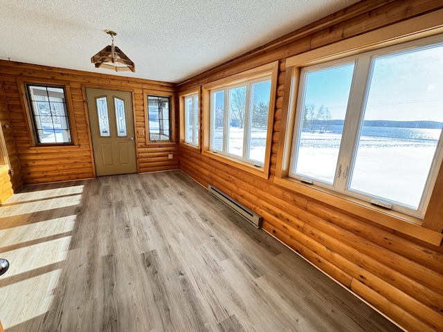 unfurnished sunroom featuring a baseboard heating unit