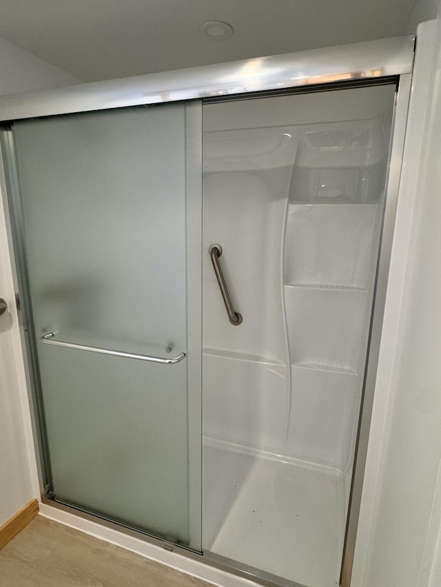 bathroom featuring a shower with door and hardwood / wood-style flooring