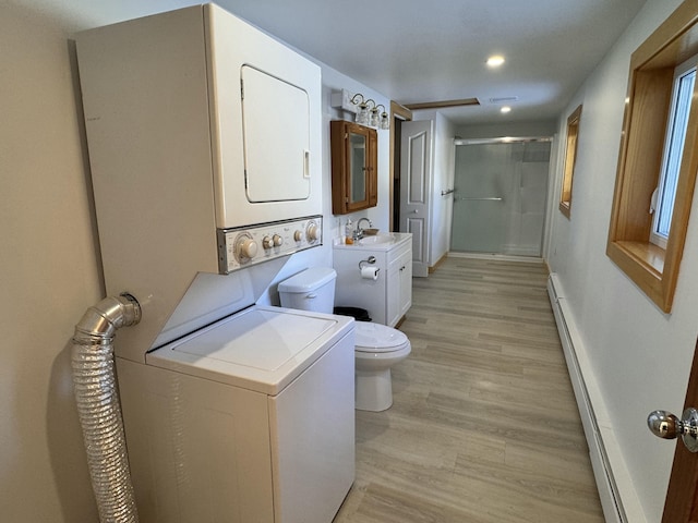 laundry area featuring stacked washing maching and dryer, sink, light hardwood / wood-style floors, and a baseboard radiator