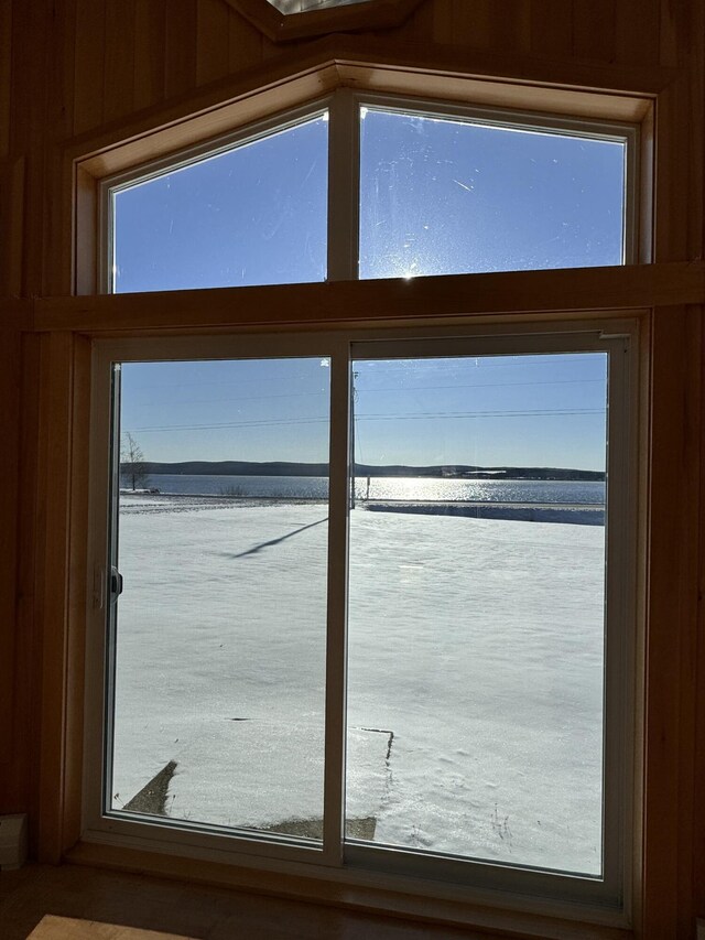 doorway with a water view and wooden walls