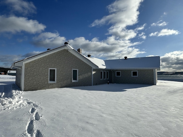 view of snow covered back of property