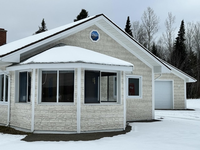 snow covered property featuring a garage