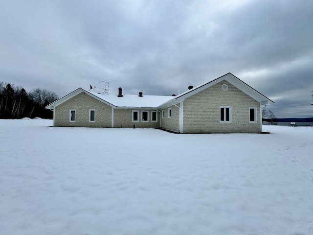 view of snow covered rear of property