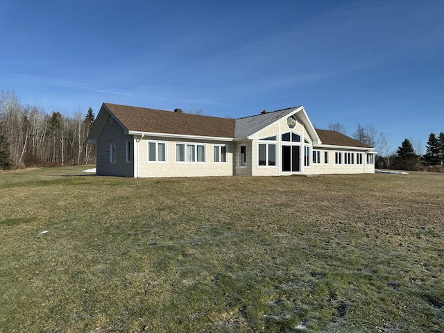 rear view of property with a yard