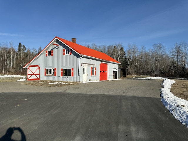 snow covered property with an outbuilding