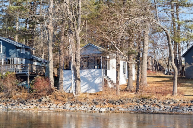 view of property exterior with a deck with water view