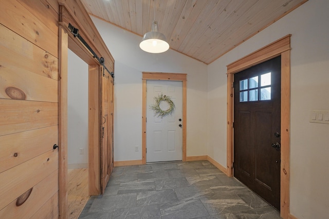 interior space with wooden ceiling, wood walls, a barn door, and vaulted ceiling