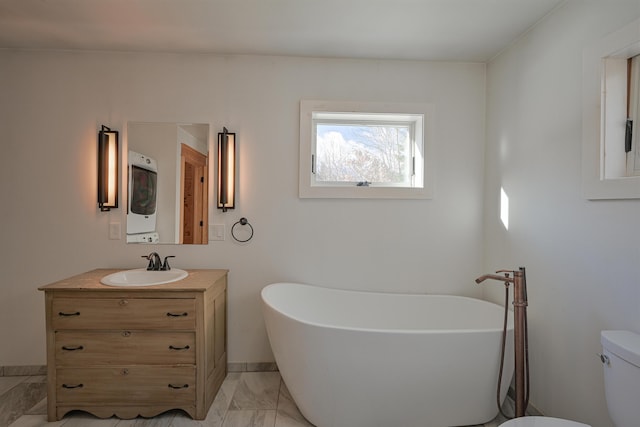 bathroom featuring toilet, a bathing tub, and vanity