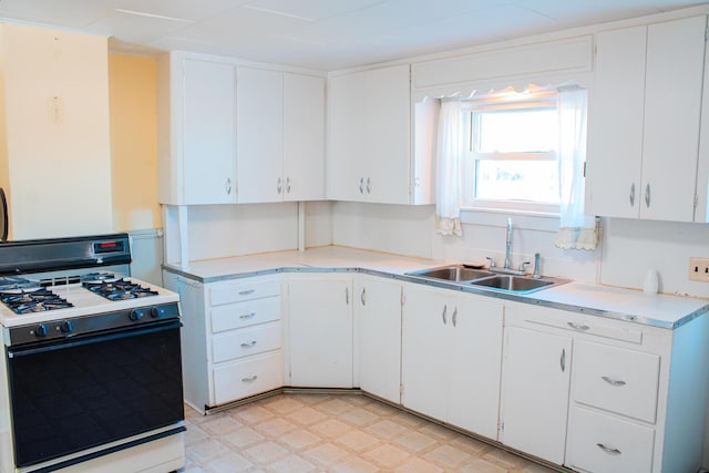 kitchen with white cabinets, white range with gas cooktop, and sink