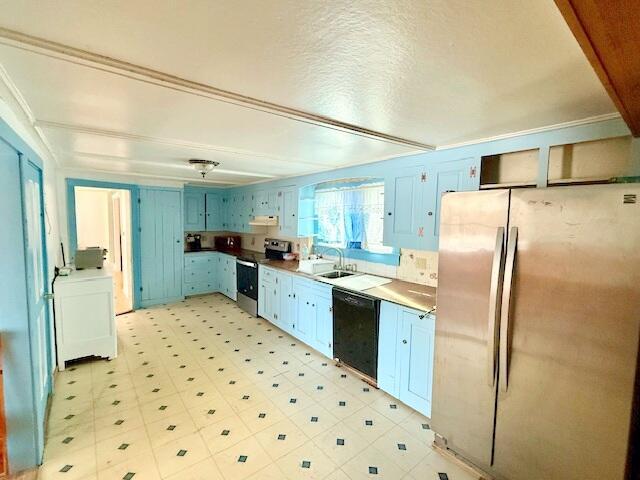 kitchen with sink, a textured ceiling, blue cabinetry, washer / dryer, and appliances with stainless steel finishes