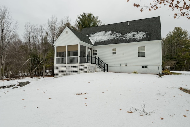 snow covered property with a sunroom and cooling unit