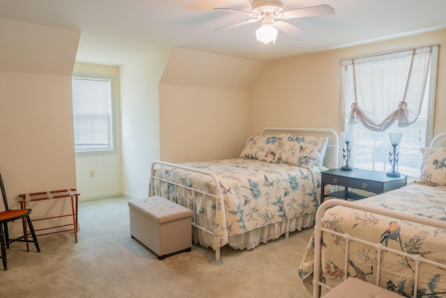 carpeted bedroom featuring multiple windows, ceiling fan, and vaulted ceiling