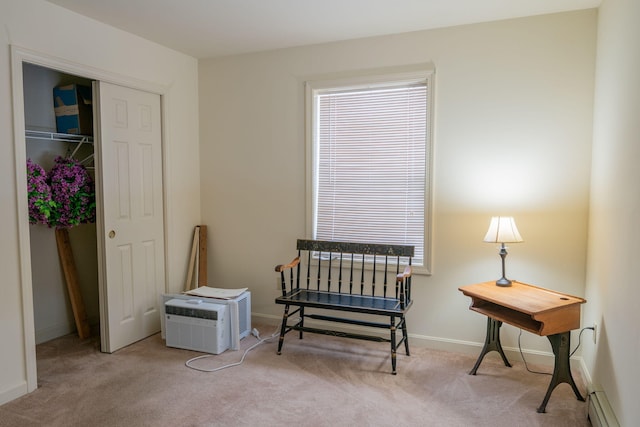 sitting room featuring baseboard heating, light carpet, and an AC wall unit