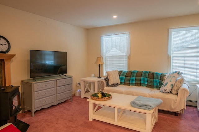 living room with plenty of natural light, carpet floors, a wood stove, and a baseboard radiator