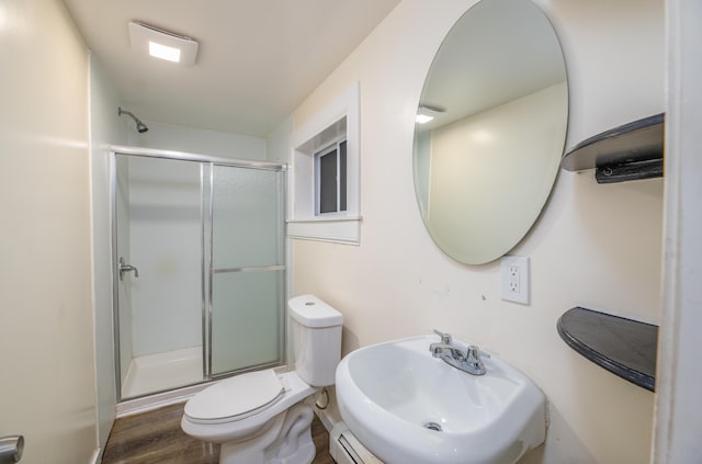 bathroom with hardwood / wood-style floors, toilet, walk in shower, and sink