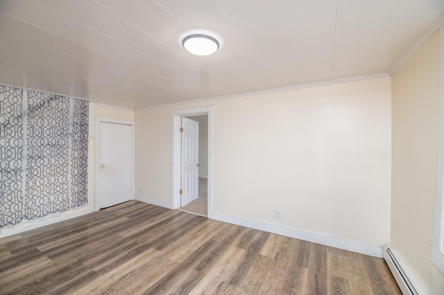 unfurnished room with hardwood / wood-style floors, ornamental molding, and a baseboard heating unit