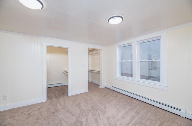 unfurnished room featuring light colored carpet and a baseboard radiator