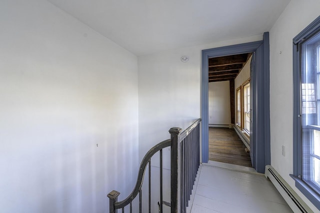 corridor featuring baseboard heating and a wealth of natural light