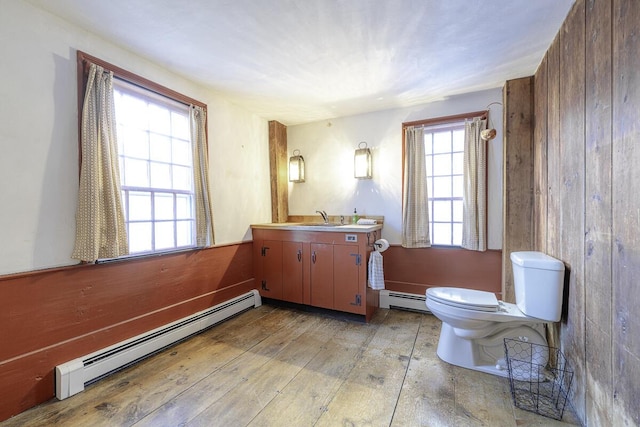 bathroom with toilet, vanity, and baseboard heating