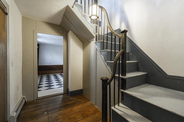 stairway featuring baseboard heating and hardwood / wood-style flooring