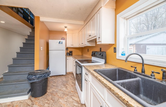 kitchen featuring white appliances, white cabinetry, and sink