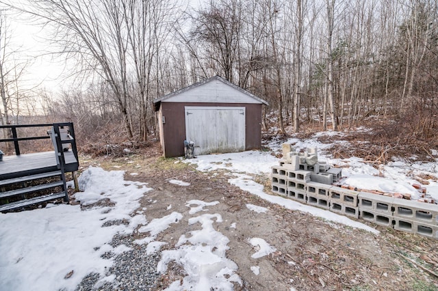 snowy yard with a wooden deck and a shed