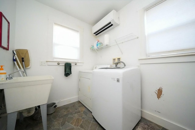 interior space with sink, washer and dryer, and a wall mounted air conditioner