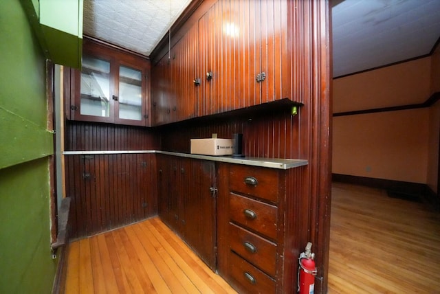 kitchen featuring wooden walls and light hardwood / wood-style flooring