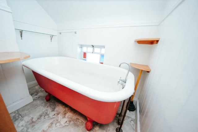 bathroom with a bath and lofted ceiling