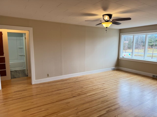 spare room with ceiling fan, light wood-type flooring, and ornamental molding