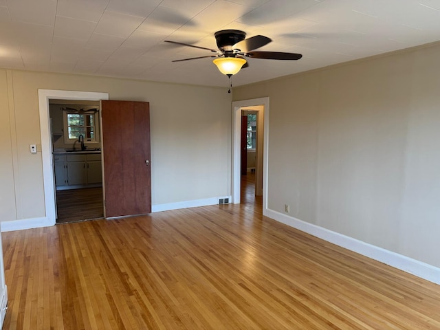 spare room featuring ceiling fan, light hardwood / wood-style floors, and sink