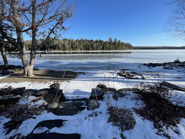 snowy yard featuring a water view