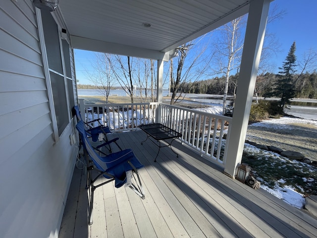 wooden terrace with a porch and a water view