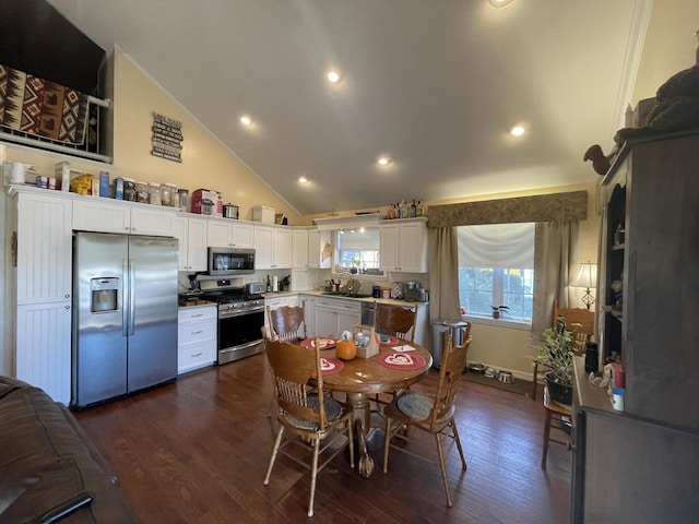 dining room featuring dark hardwood / wood-style floors, sink, and high vaulted ceiling