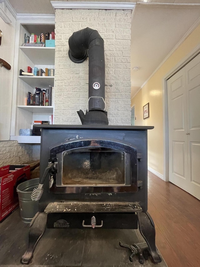 room details featuring wood-type flooring, a wood stove, and crown molding