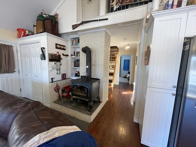 interior space featuring dark hardwood / wood-style floors, a wood stove, and crown molding