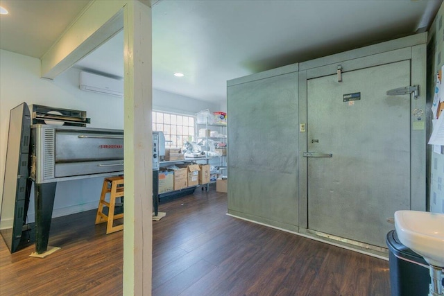 interior space featuring a wall mounted AC and dark wood-type flooring