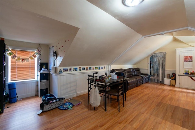 dining area with wood-type flooring and vaulted ceiling