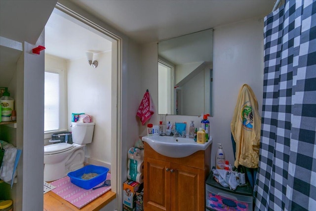 bathroom with walk in shower, vanity, and toilet