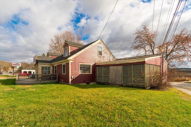 rear view of property with a yard and a wooden deck