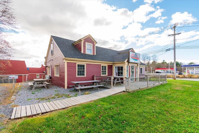 rear view of property with a yard and a wooden deck